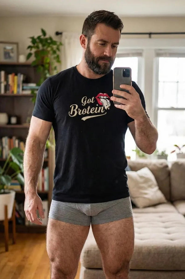 Muscular man in black funny gay shirt with Got Protein? design.