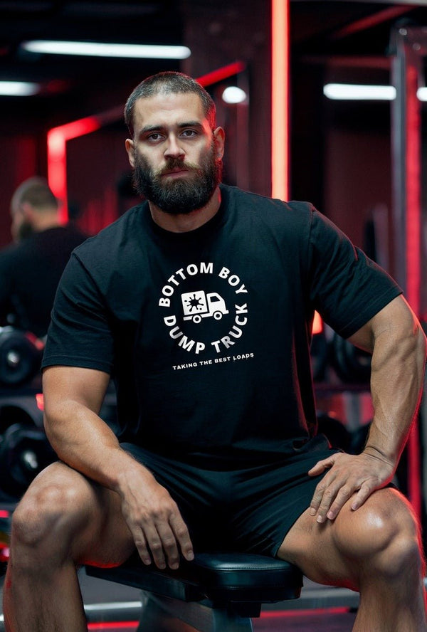 Model wearing Bottom Boy Dump Truck Shirt in gym, showcasing gay pride apparel.