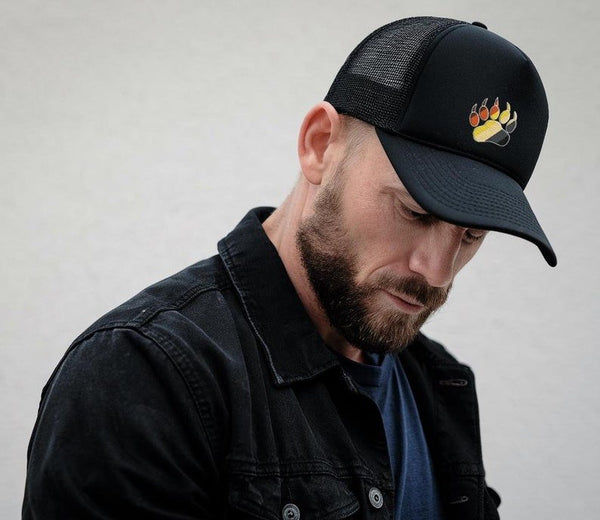 Gay Bear Trucker Hat - Gay Bear Pride LGBTQIA worn by man with beard, black cap with bear graphic.