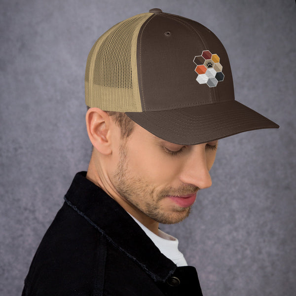 Brown trucker cap with hexagon design worn by man, perfect for pride apparel.