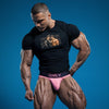 Muscular man in black shirt and pink briefs showcasing gay pride apparel.