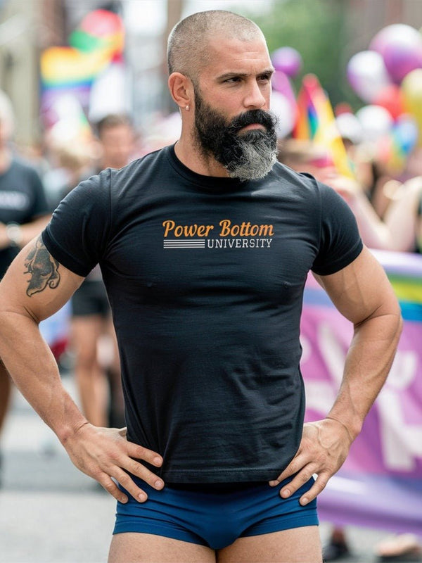 Man in black shirt showing Power Bottom University design at Pride event.